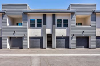 A modern building with a flat roof and a garage door.